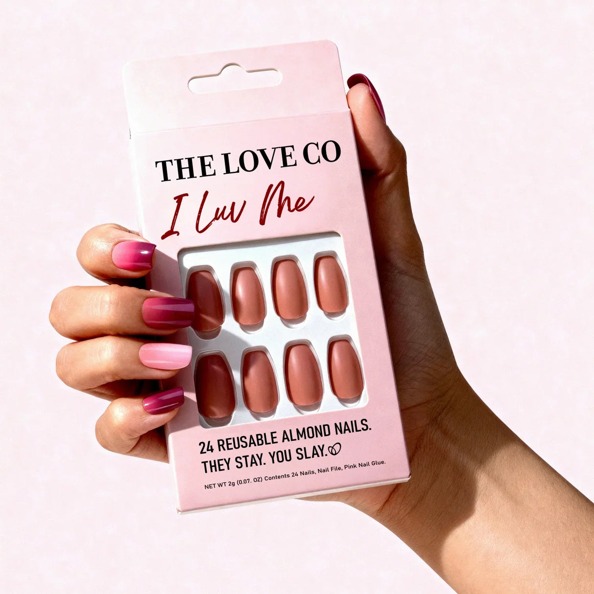 Hand holding The Love Co I Luv Me pink reusable almond nails set packaging
