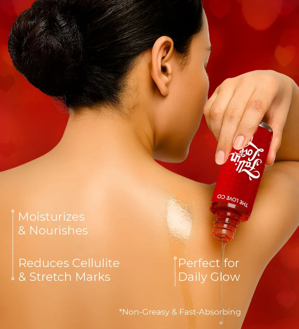 Woman applying Fall in Love body oil to shoulder, moisturizing skincare product on red background