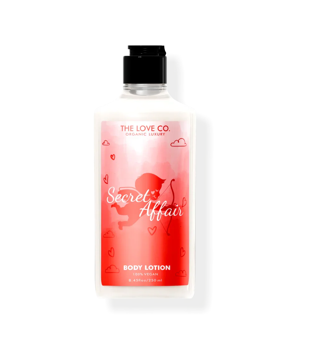 The Love Co. Secret Affair body lotion bottle with red label, cupid graphic, and hearts.
