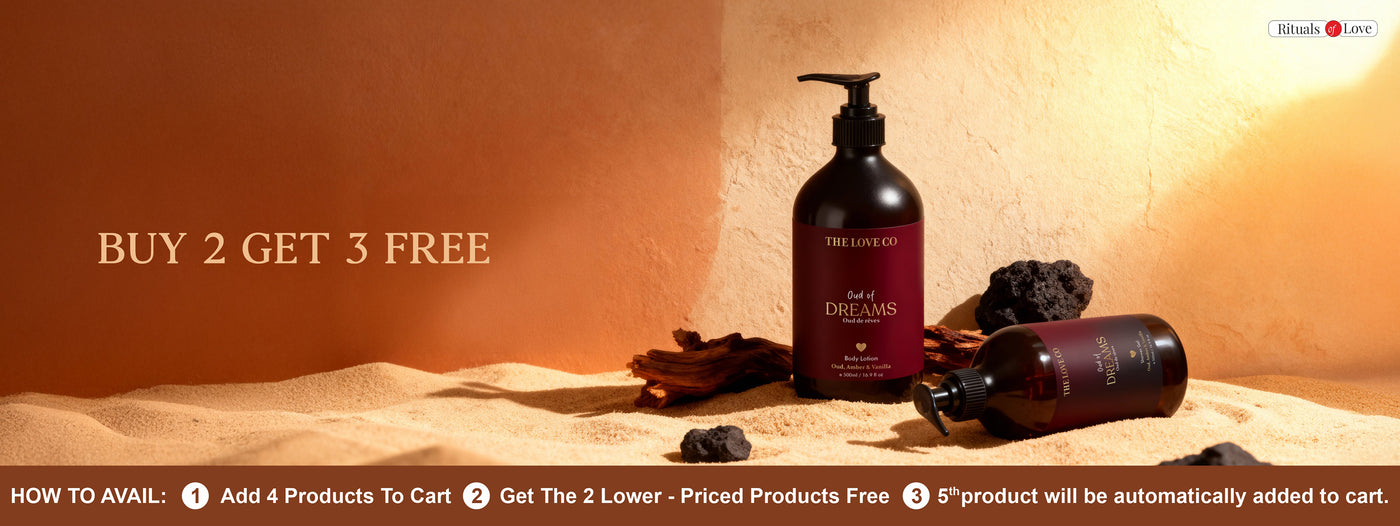 Two bottles of The Love Co products on a sand