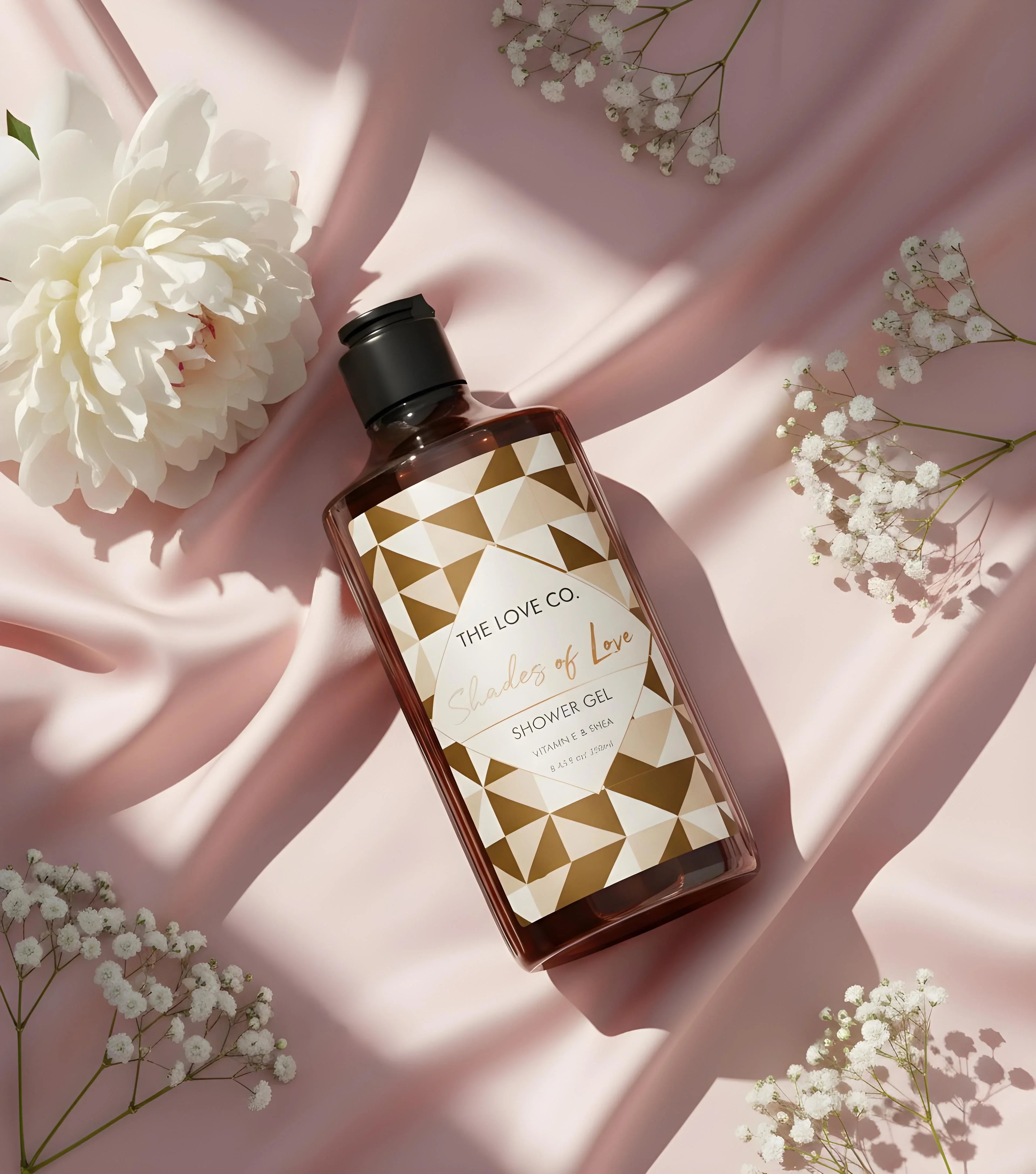 Shades of Love body wash bottle on pink satin with white flowers, elegant skincare product display