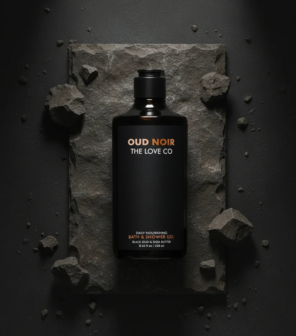 Oud Noir The Love Co body wash bottle on dark stone with rugged rocks, minimalist style