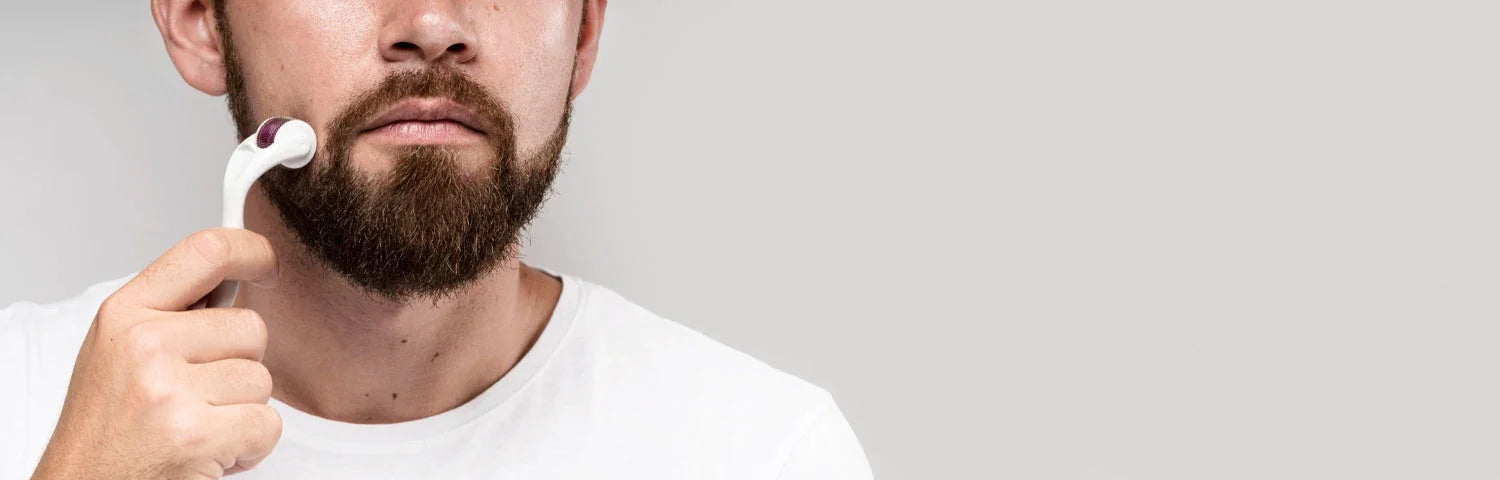 Man using a beard derma roller on facial hair against a plain background