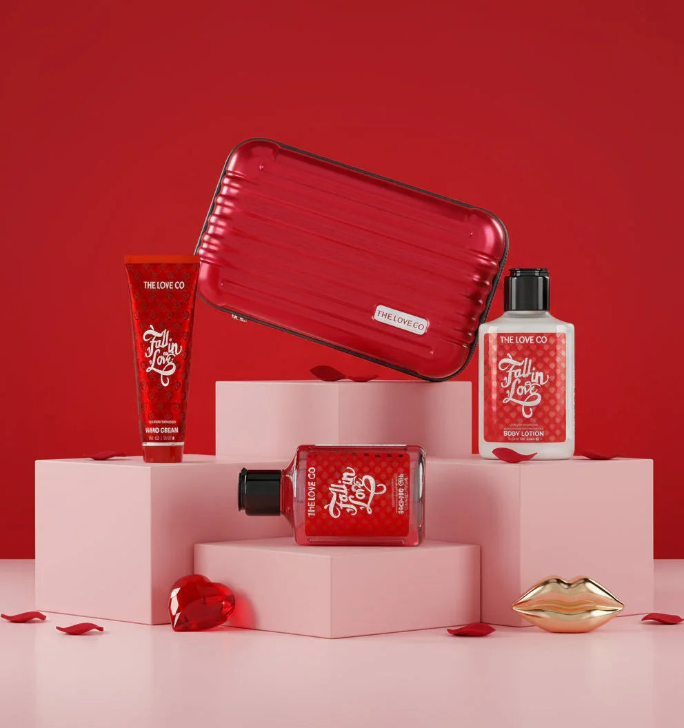 The Love Co Fall In Love gift box with hand cream, body lotion, shower gel, and red case on pink blocks