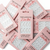 The Love Co I Luv Me pink boxes of reusable fast press-on nails arranged flat lay