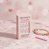The Love Co I Luv Me pink press on nails set on soft pink background with mirror and nail file