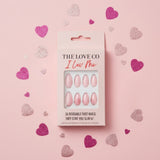 Pink press-on nails set in box with glitter hearts on pastel pink background