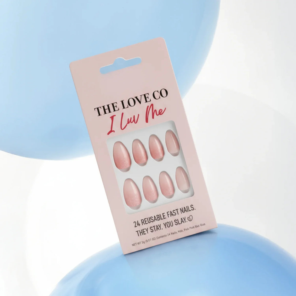 The Love Co pink press on nails set in packaging, pastel blue and white balloon background