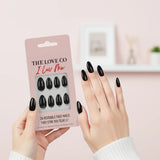 Black press-on nails from The Love Co I Luv Me, shown on hands and in packaging.