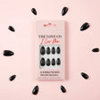 The Love Co I Luv Me black reusable press-on nails set on pink background
