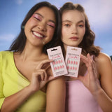 Two women holding The Love Co I Luv Me pink press-on nails packs outdoors