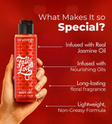 Hand holding The Love Co Fall in Love body oil, red heart bottle, body oil benefits listed