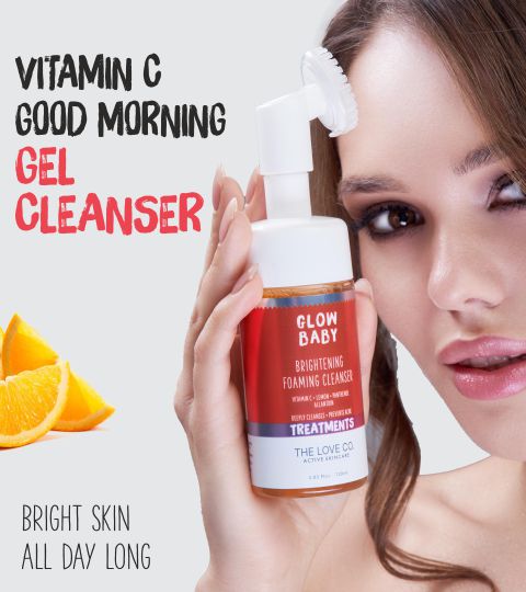 Woman holding The Love Co. Glow Baby Brightening Foaming Cleanser with Vitamin C, promising bright skin all day long