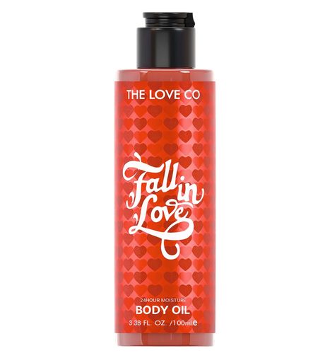 Body oil bottle with red heart pattern and 'The Love Co' branding on a white background
