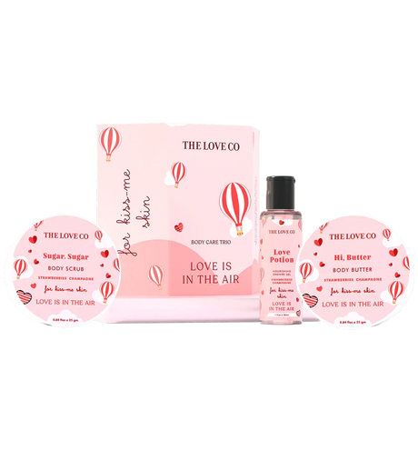 THE LOVE CO Love Is In The Air body care trio with body scrub, shower gel, and body butter in pink packaging featuring heart and hot air balloon graphics.