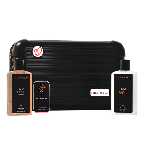 THE LOVE CO Oud of Love zipper kit with shower gel, body lotion, and solid perfume in front of a black travel case