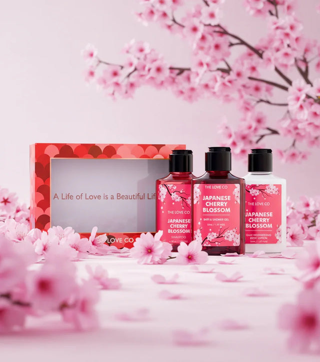 The Love Co Japanese Cherry Blossom gift set with floral bottles and pink cherry blossoms.