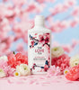 Body lotion bottle with cherry blossom design on a floral background
