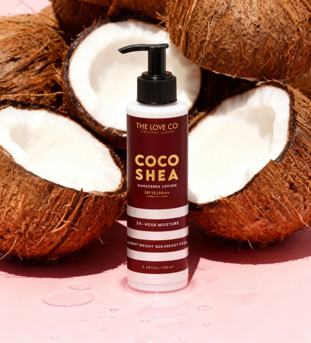 Coco Shea sunscreen lotion bottle with coconuts on a pink background