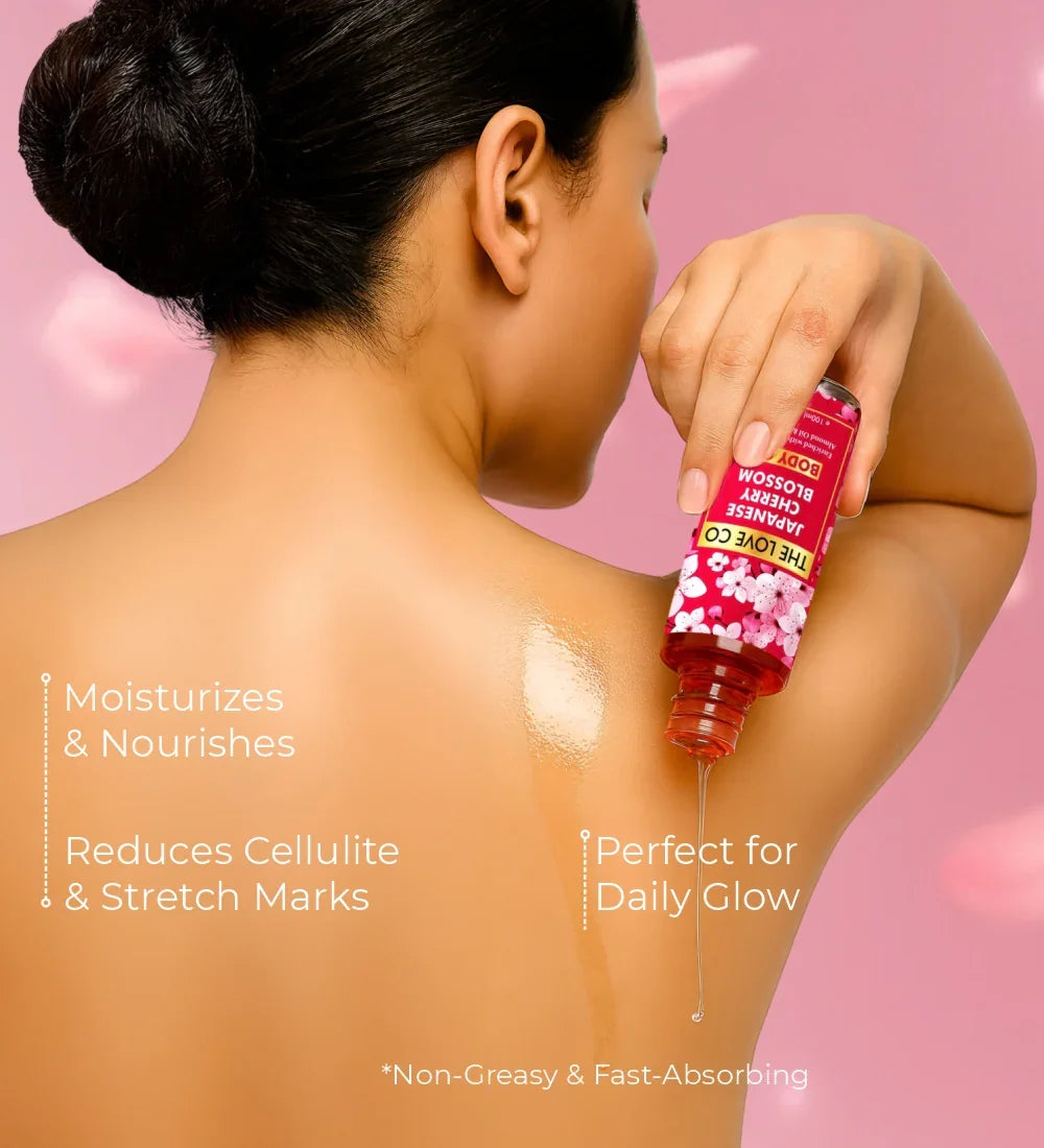 Woman applying Japanese cherry blossom body oil on back against a pink background