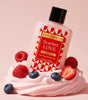 Bottle of 'Scarlett LOVE' shower gel from 'The Love Co' with berries on a pink background