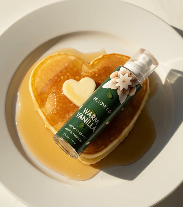 The Love Co Warm Vanilla body mist bottle on heart-shaped pancake with butter and syrup