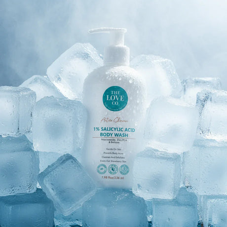 The Love Co 1% salicylic acid body wash bottle with pump surrounded by ice cubes