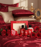 The Love Co. product set with red roses on a bed
