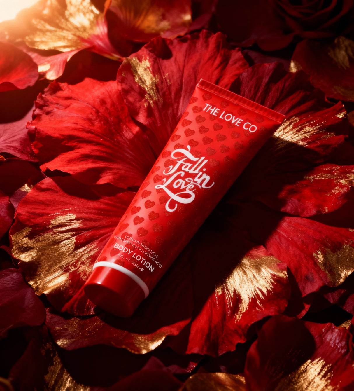 Red 'The Love Co' body lotion tube on red and gold floral petals