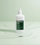 The Love Co Honeymoon Glow body lotion bottle with water drops on a light green background