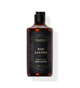 A bottle of Oud Accord Body Lotion by The Love Co. with a dark tinted liquid visible through the transparent glass and a label with black text.