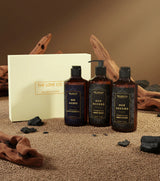 The Love Co Oud Accord gift box with body gel, hand wash, and lotion on textured surface