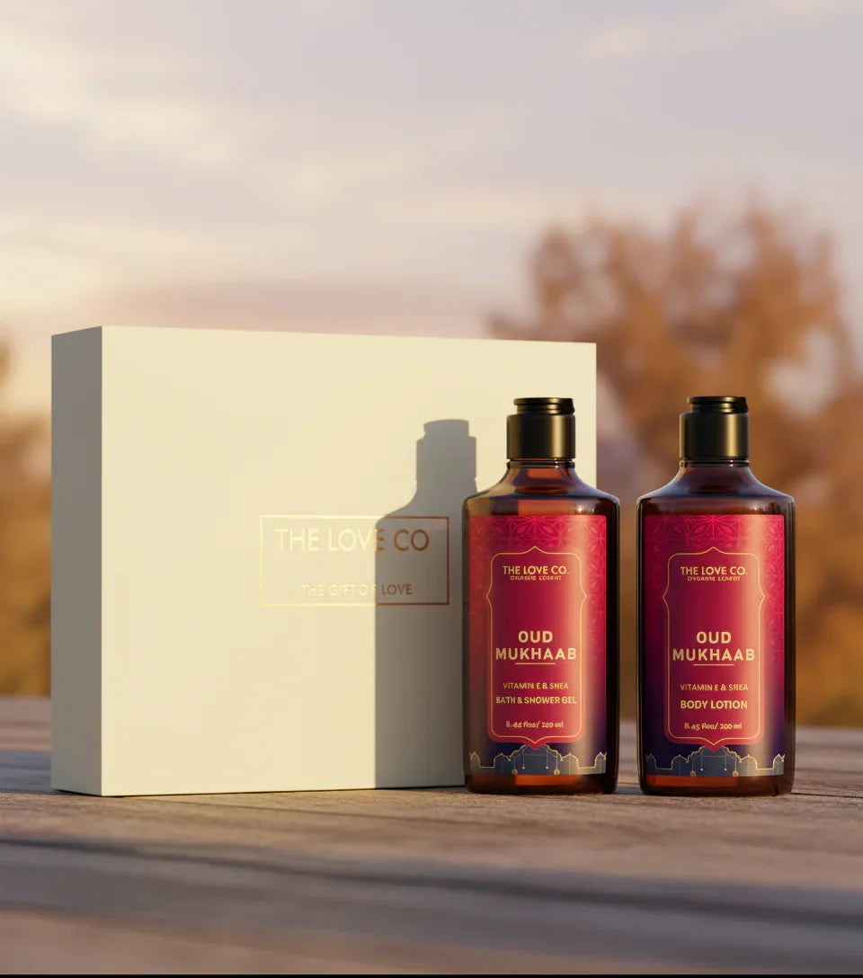 The Love Co Oud Mukhaab gift box with shower gel and body lotion on wooden surface