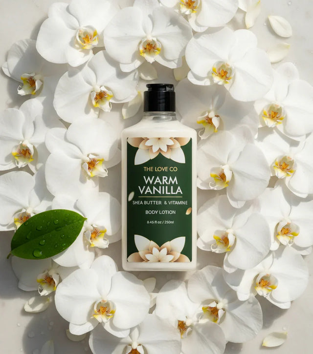 The Love Co Warm Vanilla body lotion with shea butter on white orchid flowers