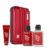 Red suitcase with 'The Love Co' products including a tube, bottles of shower gel and body lotion on a white background.