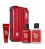 Red suitcase with 'The Love Co' products including a tube, bottles of shower gel and body lotion on a white background.